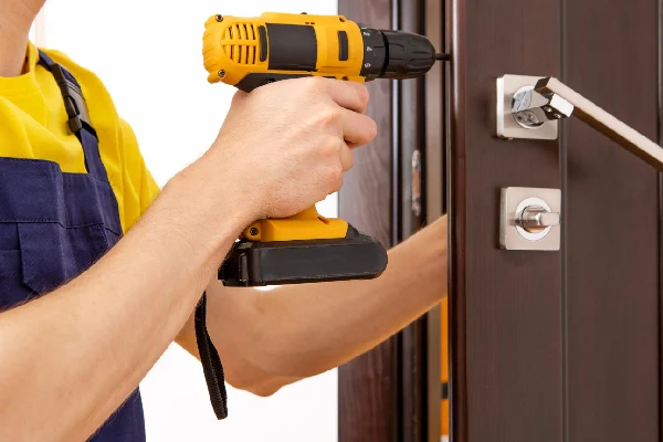 Locksmith replacing a door lock